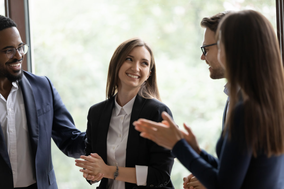 Woman laughing while her colleagues clap