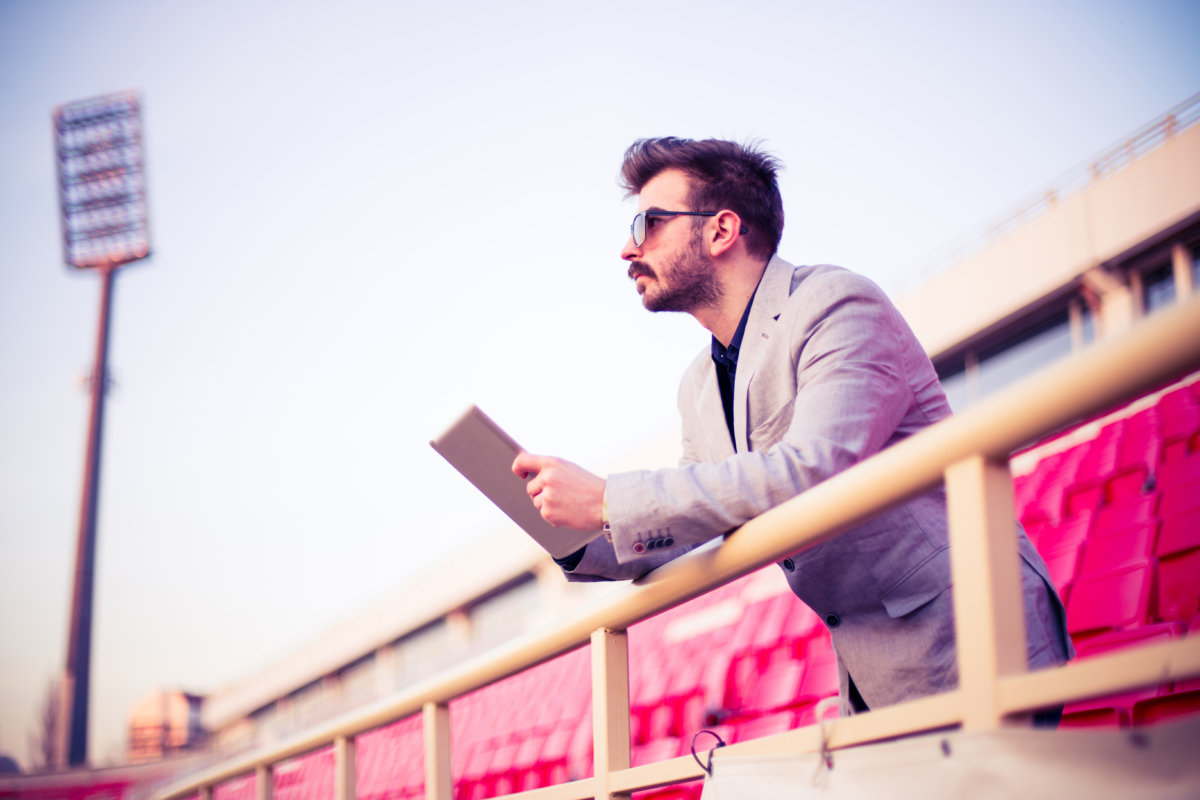 Man holding a tablet watching a game at the stadium