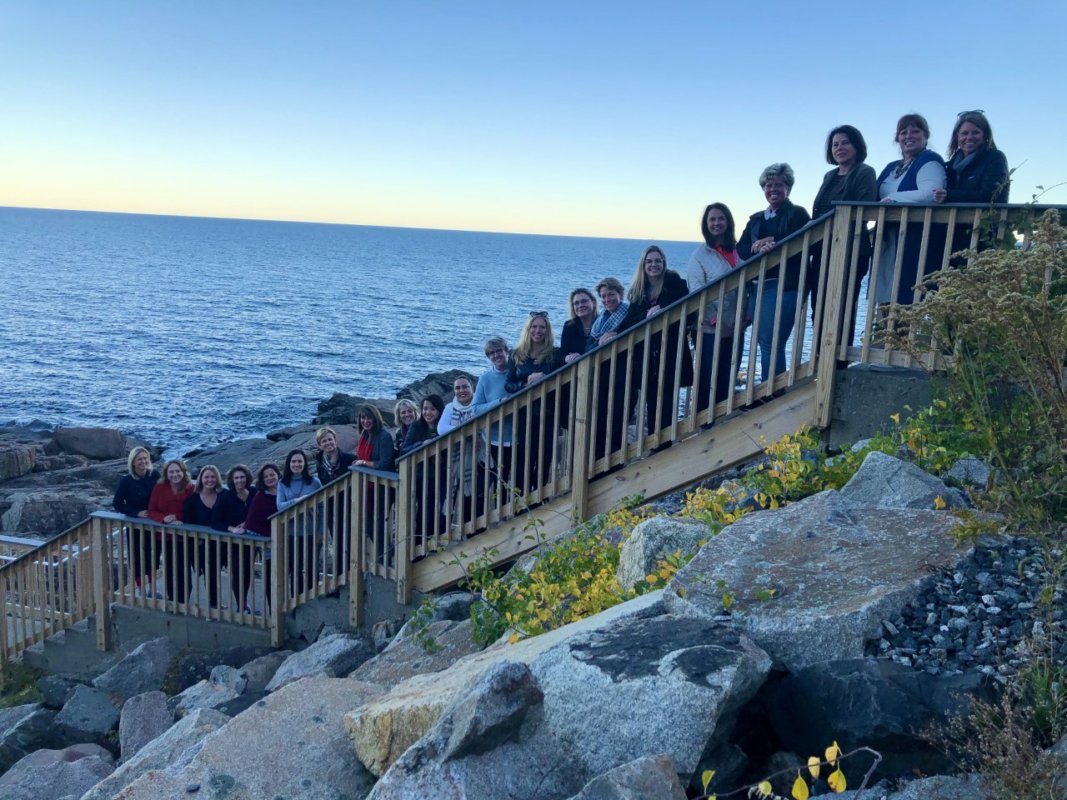 A group of people standing on top of a wooden bridge.