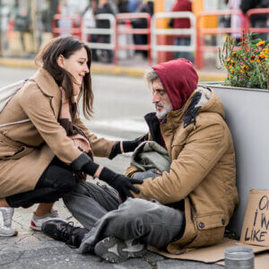 A woman acknowledging a homeless man, showcasing the importance of being seen